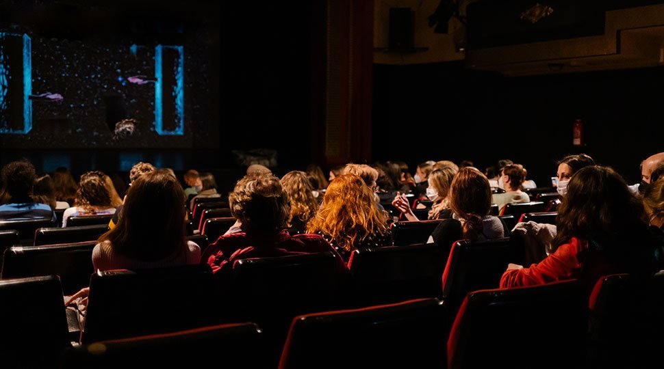 audience in dark movie theater - film festival distribution - gomakemovie