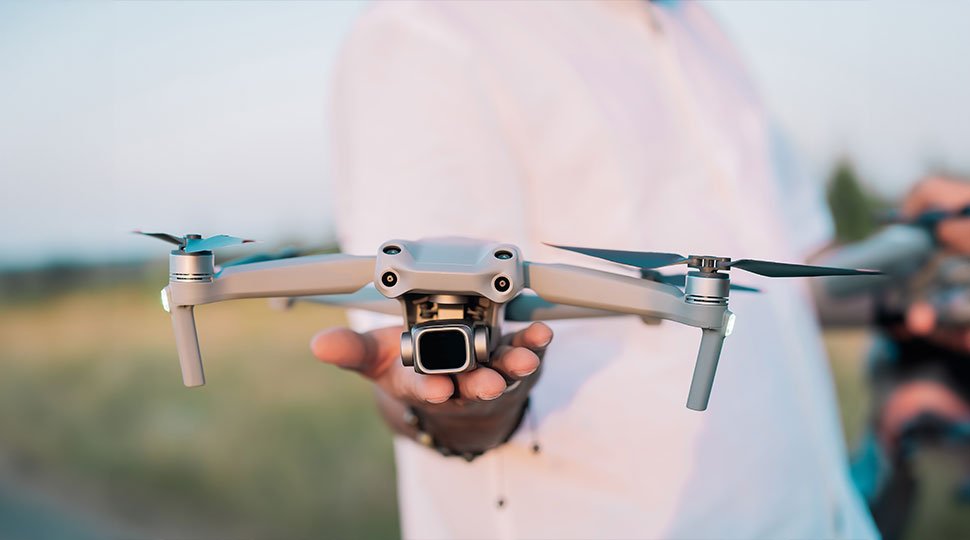 man holding drone with camera - drone cinematography - go make movie